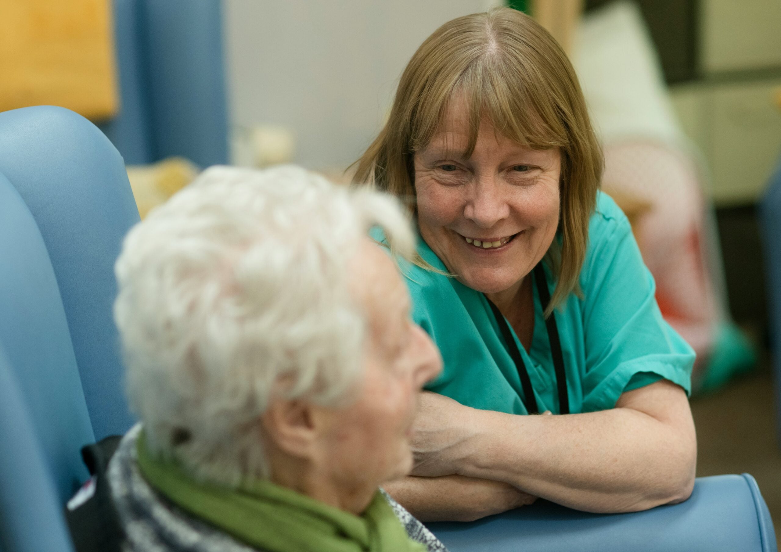 Caregiver smiling and talking with an older adult during in-home care