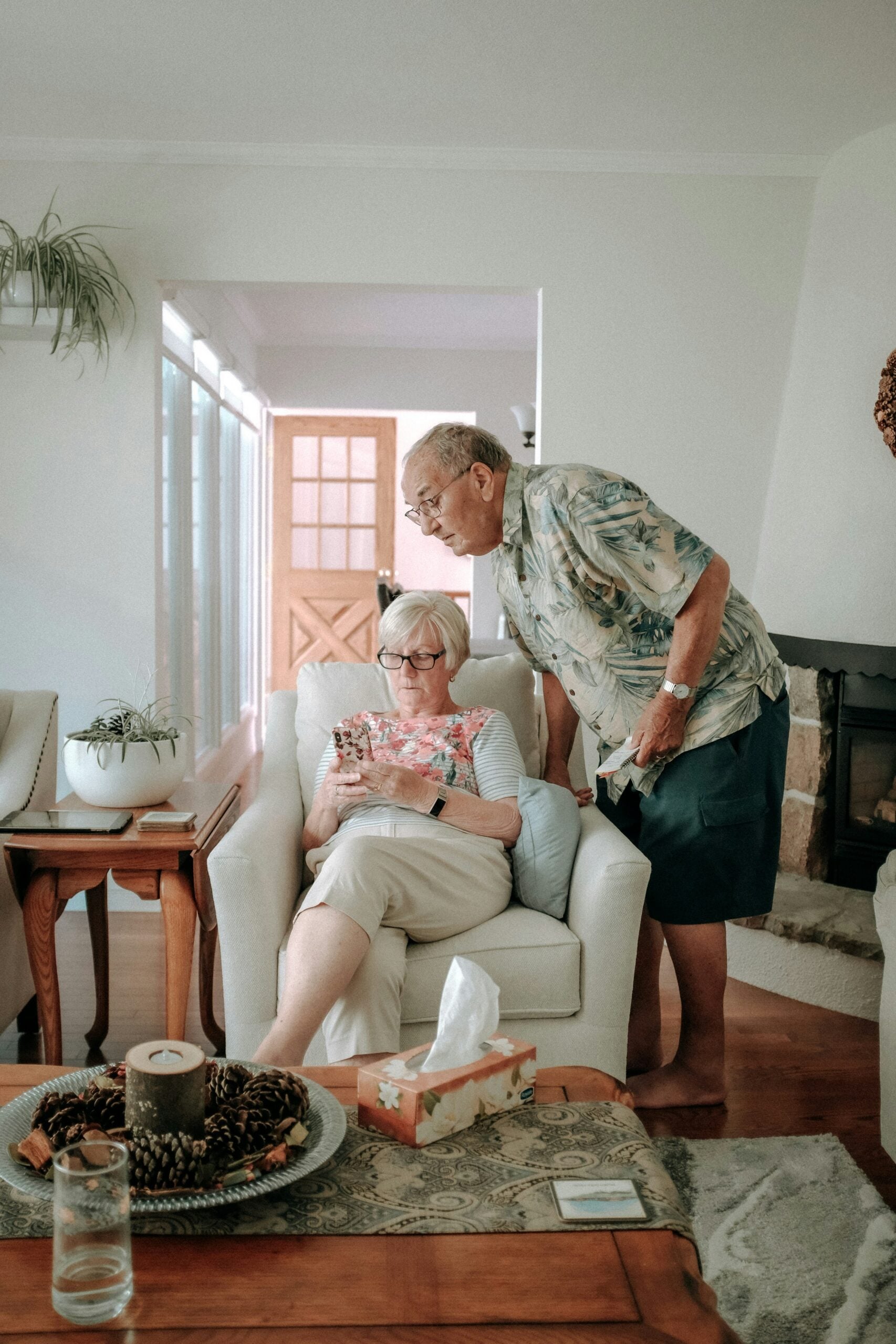 Older couple at home reviewing a smartphone together, illustrating senior independence and fall prevention awareness.
